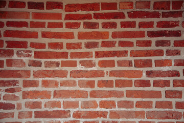 Irregular historic brickwork forming a vintage red masonry surface