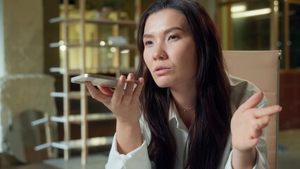 Asian business girl woman female Chinese send message audio mobile phone talking in office record...