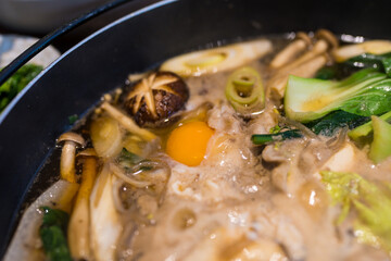 Sukiyaki hot pot simmering with and vibrant vegetables ready to enjoy. Close up