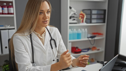 Woman doctor in clinic room discussing diagnosis with patient, showcasing blonde professional in...