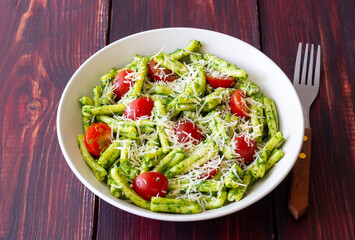 Pasta casarecce with pesto sauce, tomatoes and cheese. Italian cuisine. Vegetarian food.