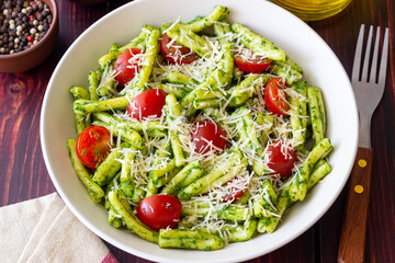 Pasta casarecce with pesto sauce, tomatoes and cheese. Italian cuisine. Vegetarian food.