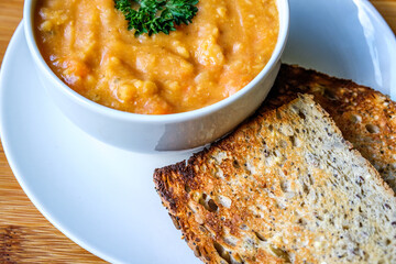 A Bowl Of Hot Nourishing Vegetarian Lentil Soup Garnished With Parsley Served With Toast