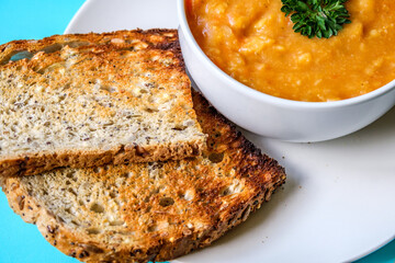 A Bowl Of Hot Nourishing Vegetarian Lentil Soup Garnished With Parsley Served With Toast