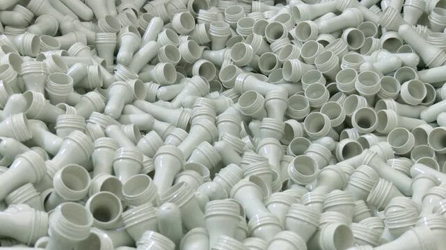 Manufacturing of bottles plastic line, bottle plastic hot blow process transportation raw material by automatic conveyer in factory. Conveyor belt deliver the preform shape to the  blow mold machine.
