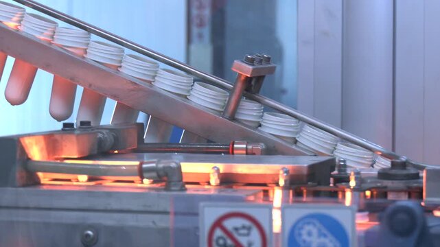 Manufacturing of bottles plastic line, bottle plastic hot blow process transportation raw material by automatic conveyer in factory. Conveyor belt deliver the preform shape to the  blow mold machine.
