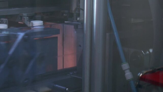 Manufacturing of bottles plastic line, bottle plastic hot blow process transportation raw material by automatic conveyer in factory. Conveyor belt deliver the preform shape to the  blow mold machine.
