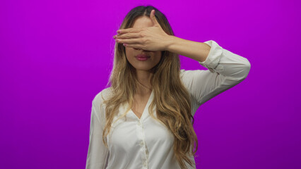 Naklejka premium Woman covers eyes with hand in studio; privacy introspection mystery secrecy.