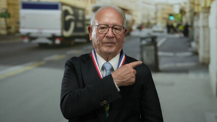 Elderly businessman in suit with medal points on street with blurred city background showing...