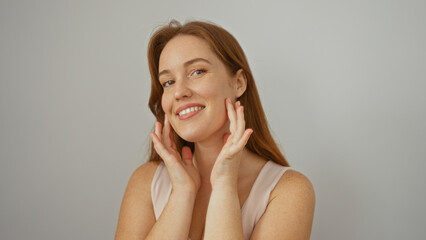 Fototapeta premium Woman smiling with hands on cheeks isolated on a white background captures a young and attractive redhead showcasing beauty.