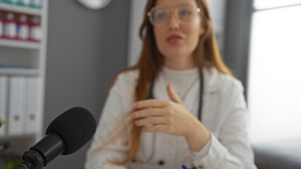 Woman doctor discussing with microphone indoors in clinic setting with bookshelves in the...