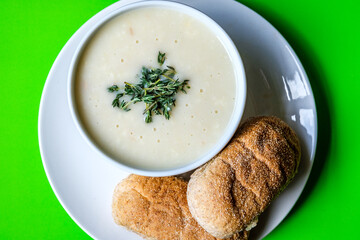 Bowl Of Chicken Soup With Thyme Garnish And Wholemeal Submarime Bread Rolls