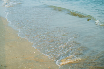 Closeup of the sea at sunset. Beach with sand.