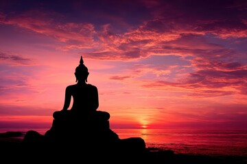 A Buddha statue silhouette sits peacefully against a vibrant sunset sky by the ocean, radiating tranquility and calm