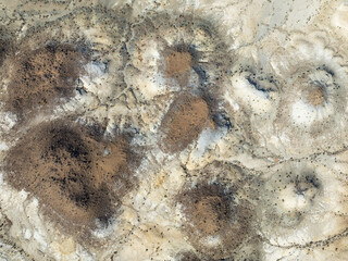 Aerial view of arid landscape with contrasting textures and tonal variations across the terrain, creating a dramatic visual impact, Keetmanshoop, Karas Region, Namibia.