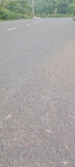 Asphalt Road Surface:  Close-up Texture, Rural Setting, Serene Mood, Blurred Background.