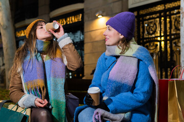Women drinking coffee and resting after christmas shopping