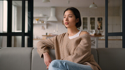 Sad Caucasian latin hispanic woman girl female tenant on sofa deep unhappy thoughts think looking...