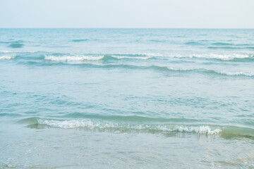 Closeup of the sea at sunset. Beach with sand.