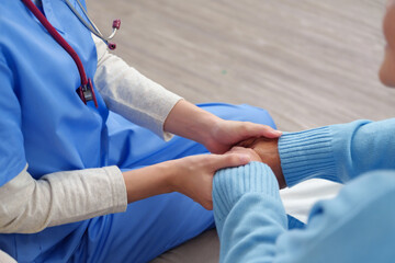 Physiotherapist provides gentle hand-holding to elderly patient, offering steady support and...