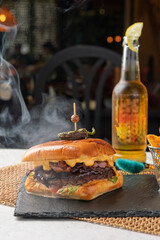 Smoking hot burger with beer and fries in a restaurant setting
