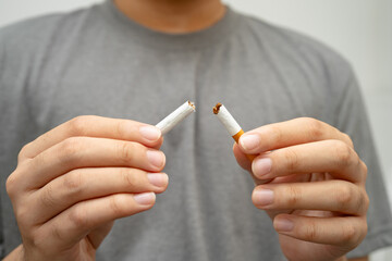 Quit smoking, Asian teenage man breaking destroy cigarette in hand.