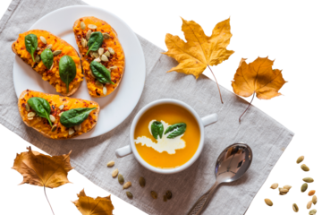 Cozy autumn lunch with creamy pumpkin soup and bruschetta with pumpkin puree and spinach. Top view flat lay, isolated on a transparent png background