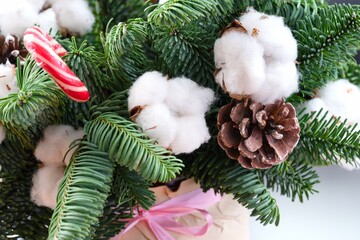 Christmas winter floral composition with cotton flowers, spruce branches, spruce cones and candy cane. Close-up