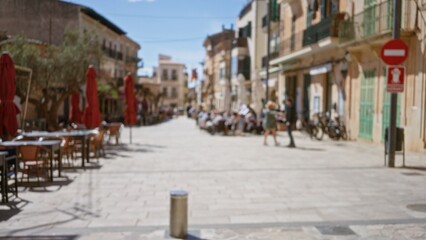 Fototapeta premium Defocused view of a mediterranean street with blurred pedestrians walking past old town buildings and outdoor cafes under bokeh sunlight creating a relaxed european atmosphere.
