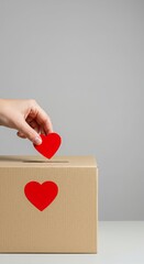 One hand puts a heart-shaped sticker on the donation box