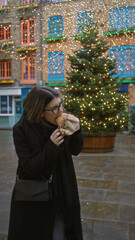 Woman enjoying festive meal on a vibrant london street with christmas lights illuminating neils yard featuring a decorated tree capturing a young hispanic holiday atmosphere