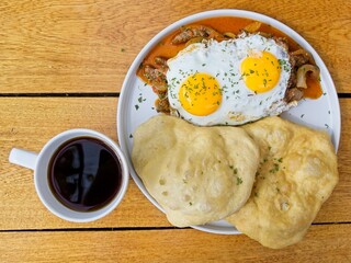 A typical Panamanian breakfast with eggs, beef steak in creole sause and hojaldres with black, high-altitude coffee.