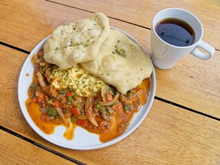 A typical Panamanian breakfast with eggs in creole sause and hojaldres with black, high-altitude coffee.