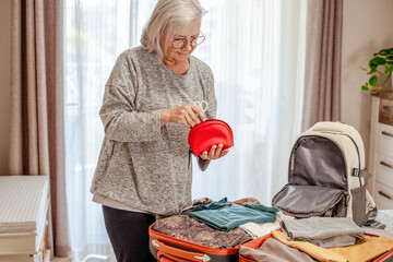 Travel and luggage concept, elderly woman ready to leave for journey after preparing luggage case...