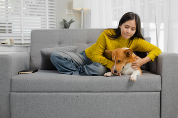 Smiling and friendly Asian female veterinarian examining dog with stethoscope and taking notes on clipboard in clinic. Veterinarian concept.