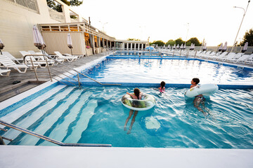 Family enjoying swimming pool fun during a sunny day at the resort