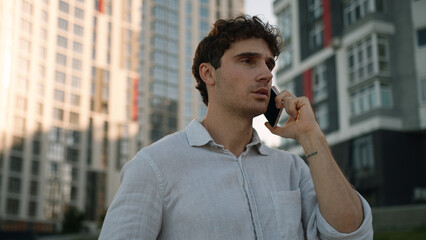 Caucasian man holding mobile phone smartphone cellphone talking conversation guy call communication...