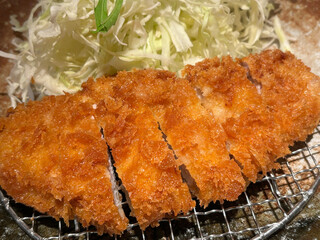 Closeup of delicious tonkatsu with cabbage, a popular Japanese dish of deep-fried pork cutlet.