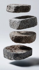 Five rough, gray cobblestones levitate in a vertical stack against a clean, minimal background, symbolizing balance, nature, and grounded energy