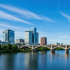 Naklejka premium Modern city skyline with arched bridge over blue water on a sunny day