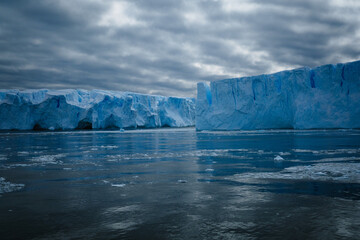 An aerial perspective showcases the dramatic melting icebergs of Antarctica, where the vivid blue...
