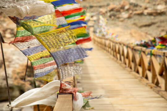 Colorful prayer flags on a wooden bridge in Ladakh
