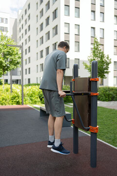 Man exercising on parallel bars in outdoor park setting