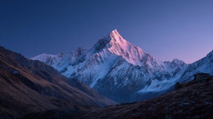 Fototapeta premium Majestic Snow Capped Mountain Peak at Sunrise with Clear Sky and Rugged Terrain.