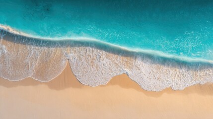 Aerial view of pristine sandy beach shoreline with gentle waves and clear turquoise water.