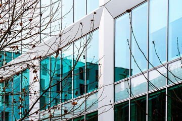 Modern Glass Facade with Reflective Panels and Angular Architectural Details in Urban Design