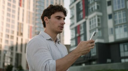 Concentrated Caucasian man business entrepreneur businessman male city employee using mobile phone smartphone guy chatting browsing internet gadget addiction typing message outdoors cellphone screen - Powered by Adobe