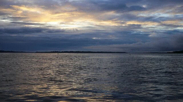 Amazon River at sunset view. Calm water reflecting orange sky, dense rainforest coastline. Peaceful, natural landscape, tropical jungle, South America, scenic beauty, golden hour