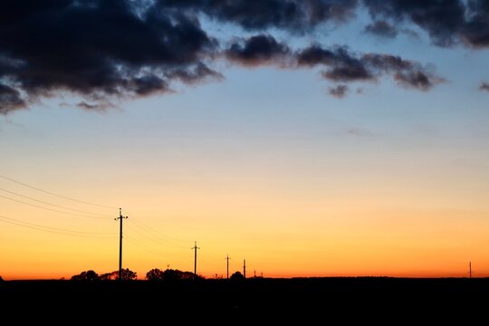 Silhouette of power lines at sunset. - Powered by Adobe