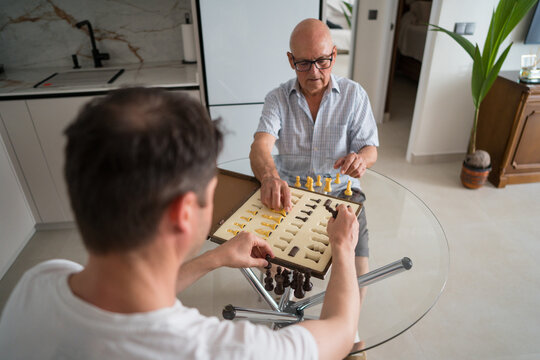 Father and son enjoying a chess game at home